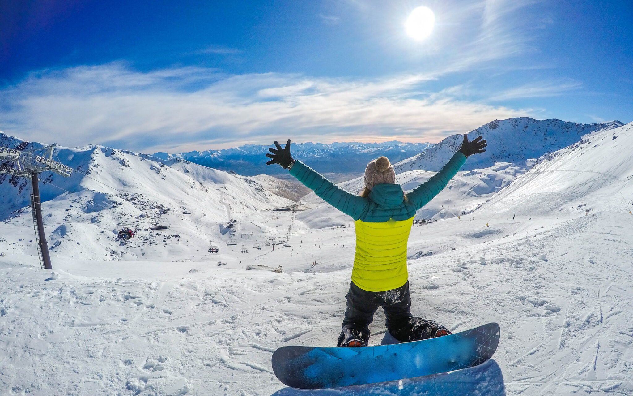 Winter sport activity.Woman holding snowboard, overlooking mountain
